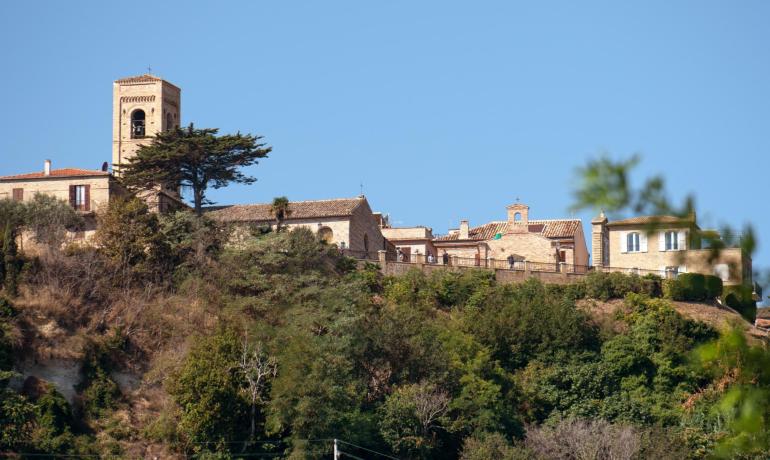 Paysage de colline avec église et maisons historiques.