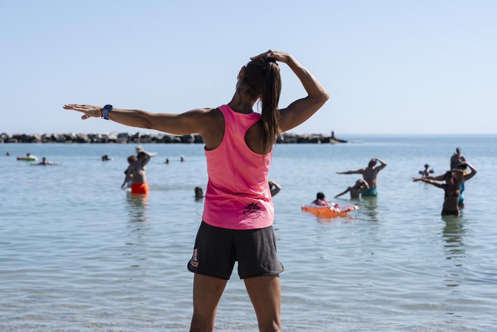 Wasserfitnesskurs mit Trainer am Strand.