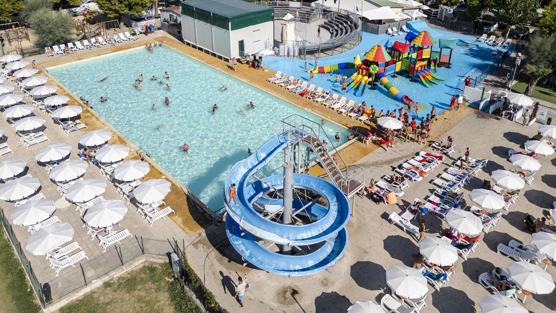 Parc aquatique avec piscine, toboggans et aire de jeux colorée pour enfants.