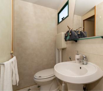 Petite salle de bain avec lavabo, miroir et fenêtre.