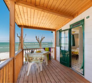 Terrasse en bord de mer avec table dressée et vue panoramique.