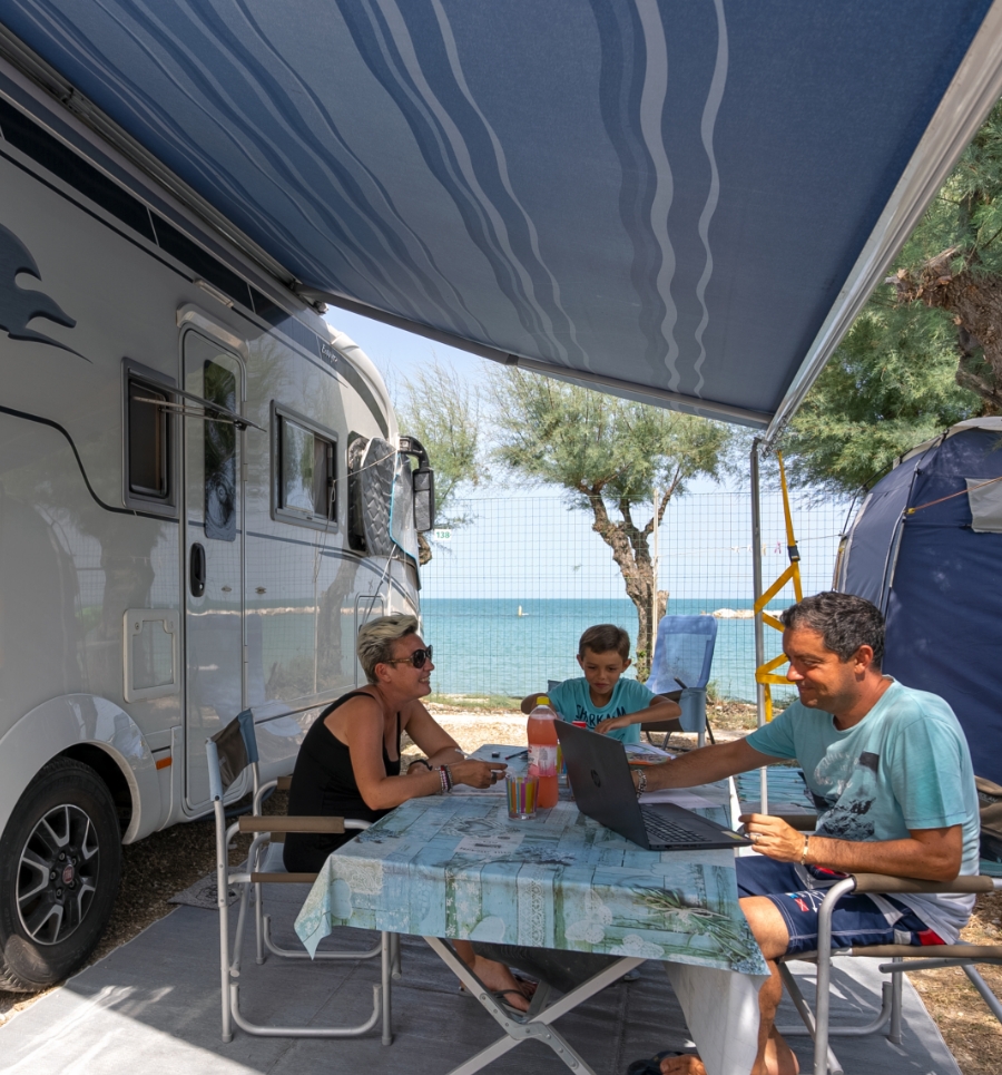 Famiglia in campeggio vicino al mare, sotto la tenda.